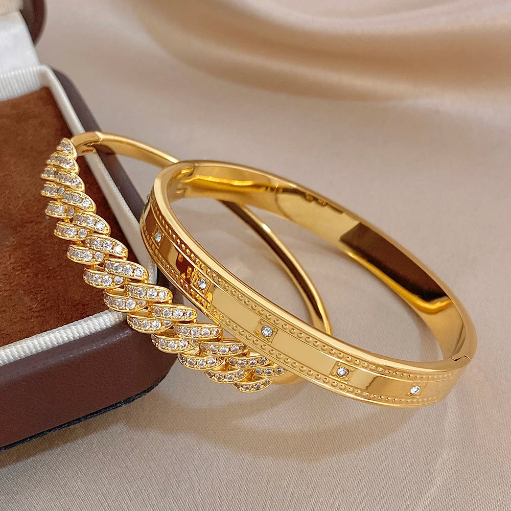 Gold tone bangle bracelet set with clear rhinestone row inlays and textured geometric trim.