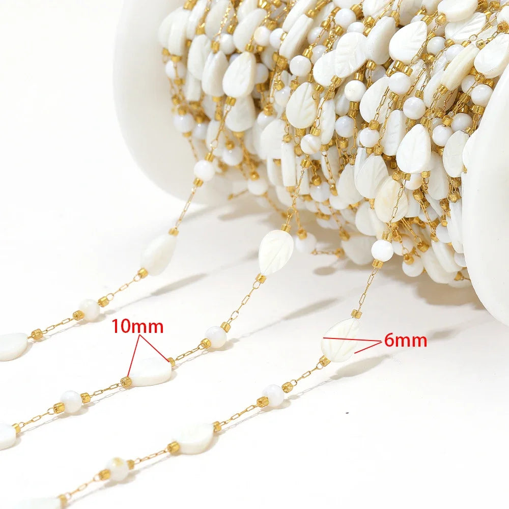 Shell bead jewelry chain strand with white oval shells and gold-tone separators (10mm/6mm marked)
