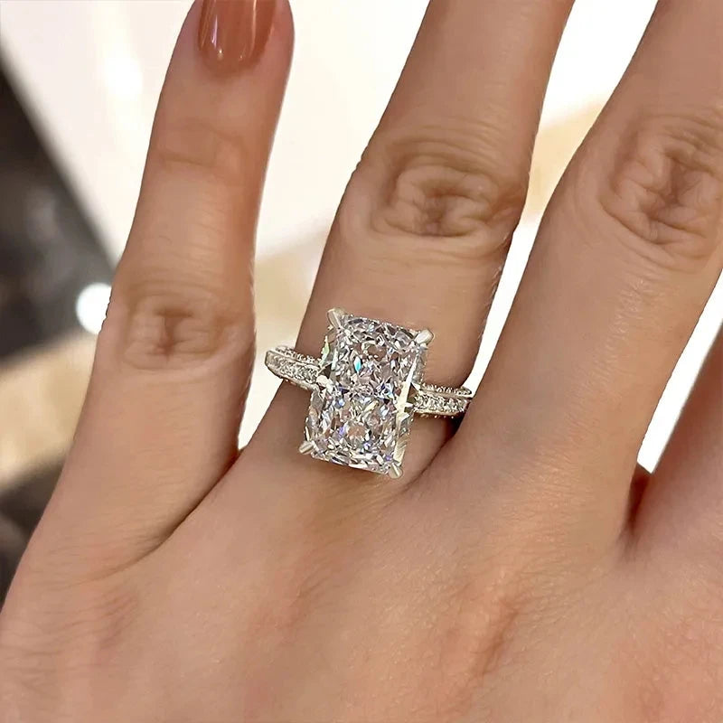 Square bezel CZ ring with textured band and double halo, shown on palm