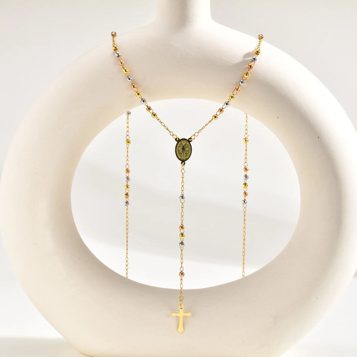 Gold-tone Y-shape rosary necklace on bust with Virgin Mary medallion and cross charm