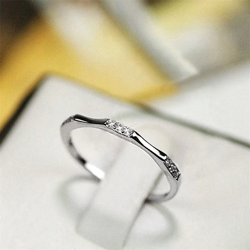 Minimalist silver wedding ring with small cubic zirconia accents