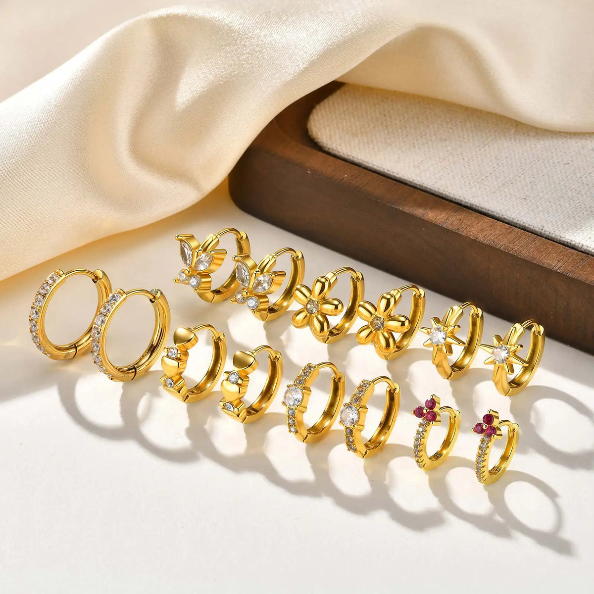 Gold-tone huggie hoop earrings set with clear CZ and small pink stone details
