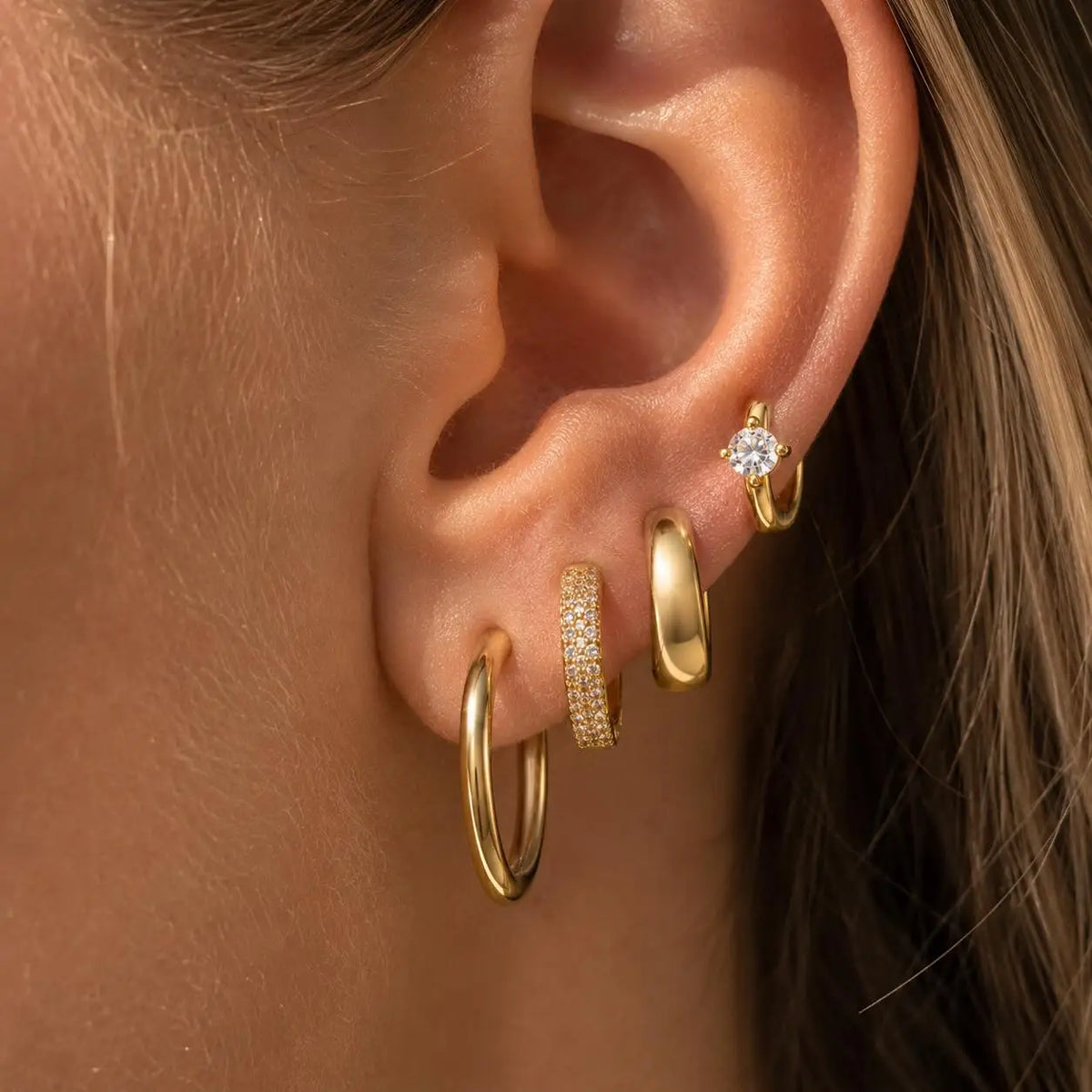 Gold-plated CZ huggie hoops and studs set, stacked on ear with small round stones