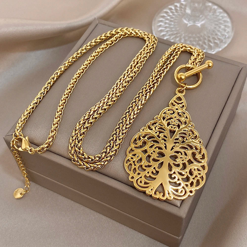 Gold-tone waterdrop filigree pendant necklace on layered chain styling