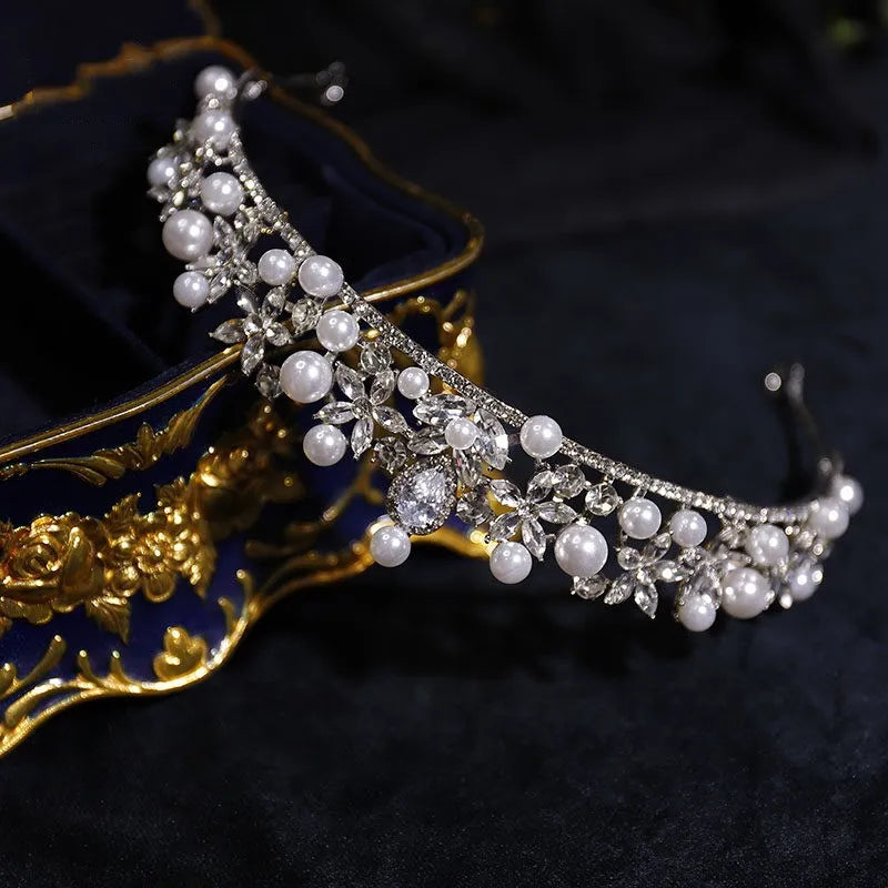 Silver rhinestone tiara with pearl drops and floral settings, angled side view