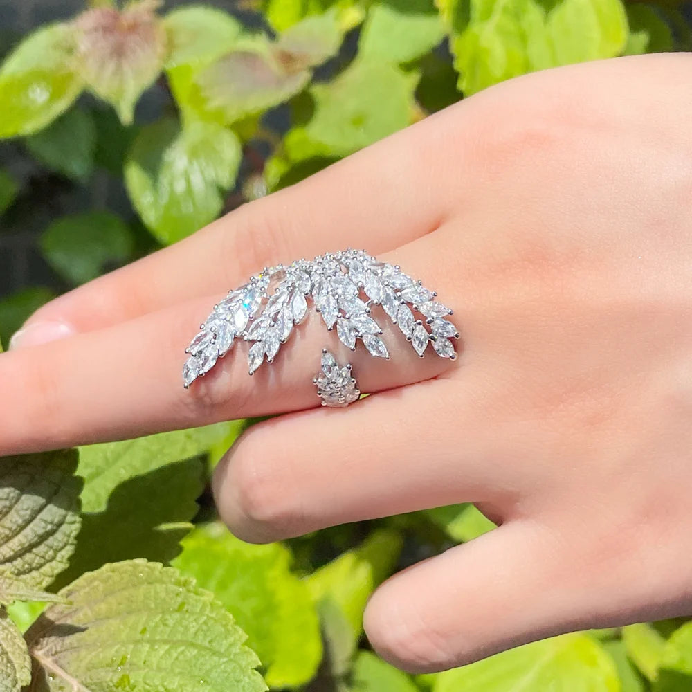 Silver-tone leaf ring shown from the side, with clear stones and an open band