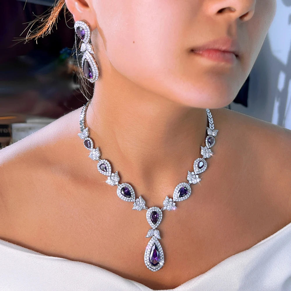 Teardrop crystal necklace with purple stones and matching drop earring, worn close-up