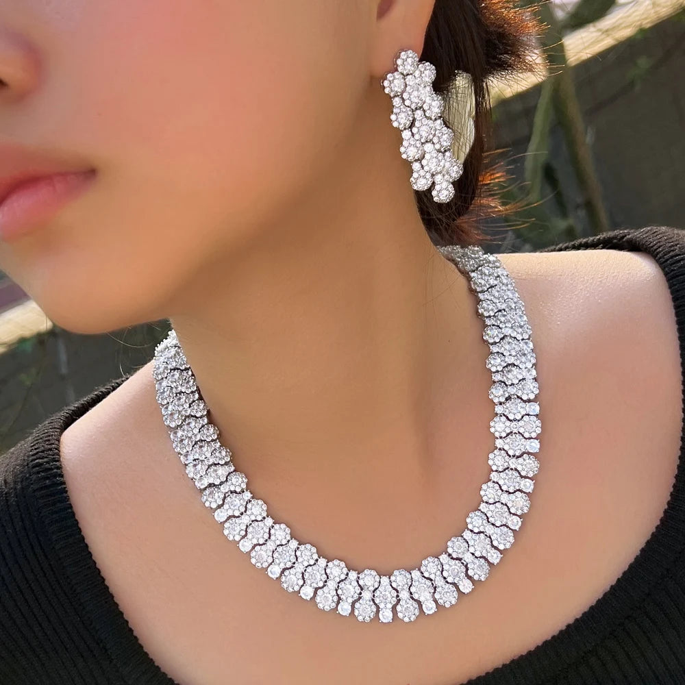 Silver-tone cubic zirconia necklace and matching flower-shaped drop earrings worn together
