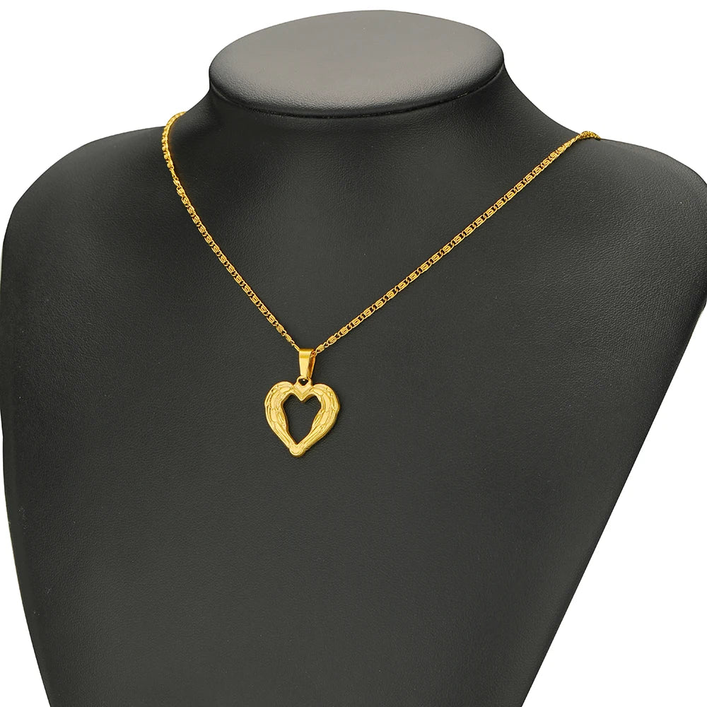Gold-tone heart pendant necklace with fine chain on dark mannequin