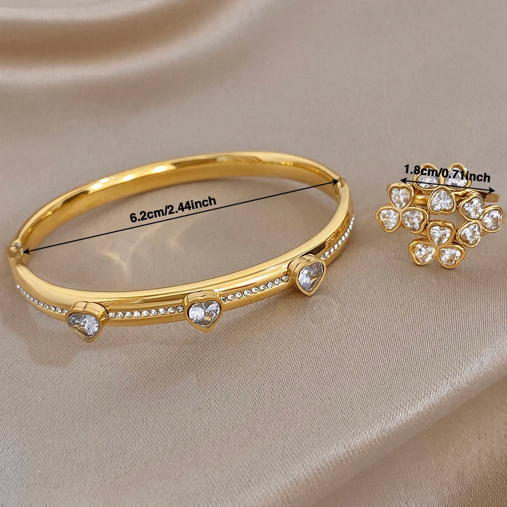 Gold-tone heart-stone bangle bracelet with clear round gems along the band