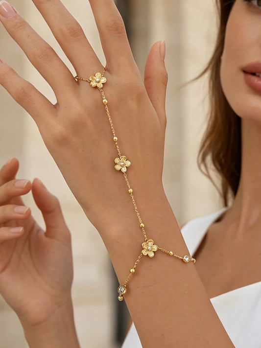 Gold-tone flower charm beaded bracelet with small white stone accents on chain