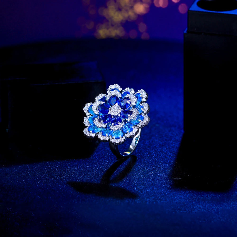 Blue cubic zirconia floral ring shown from an angled side view