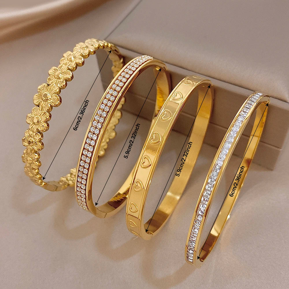 Stacked gold tone heart-carved bangles with full rhinestone inlay