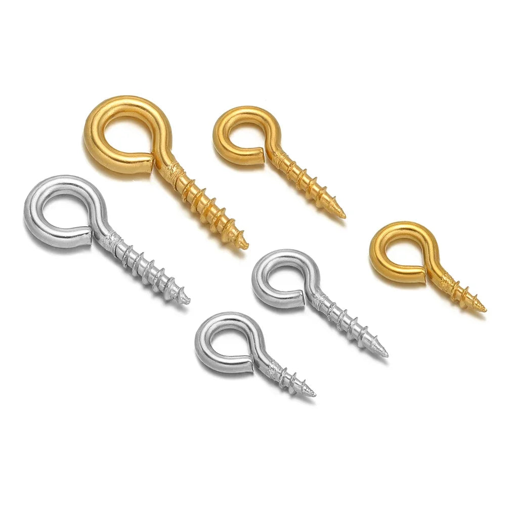 Assorted gold and silver screw eye pins with threaded shafts and looped eye hooks