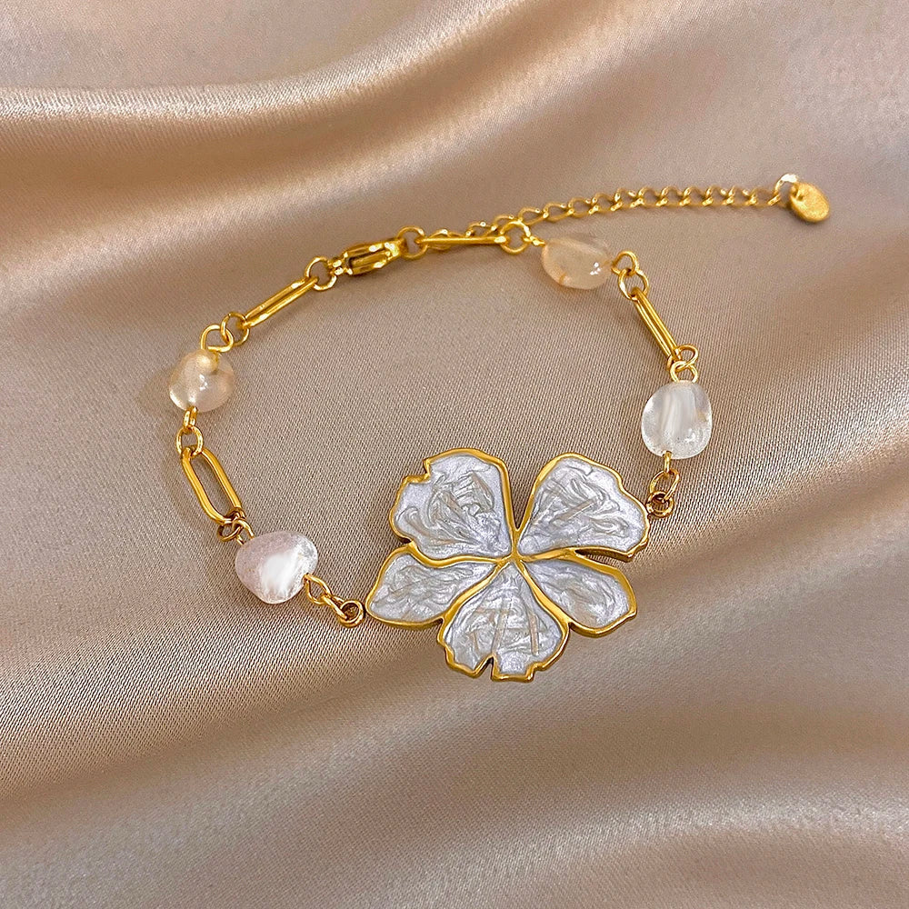 Gold plated bracelet with white and pink beads and white enamel flower center charm