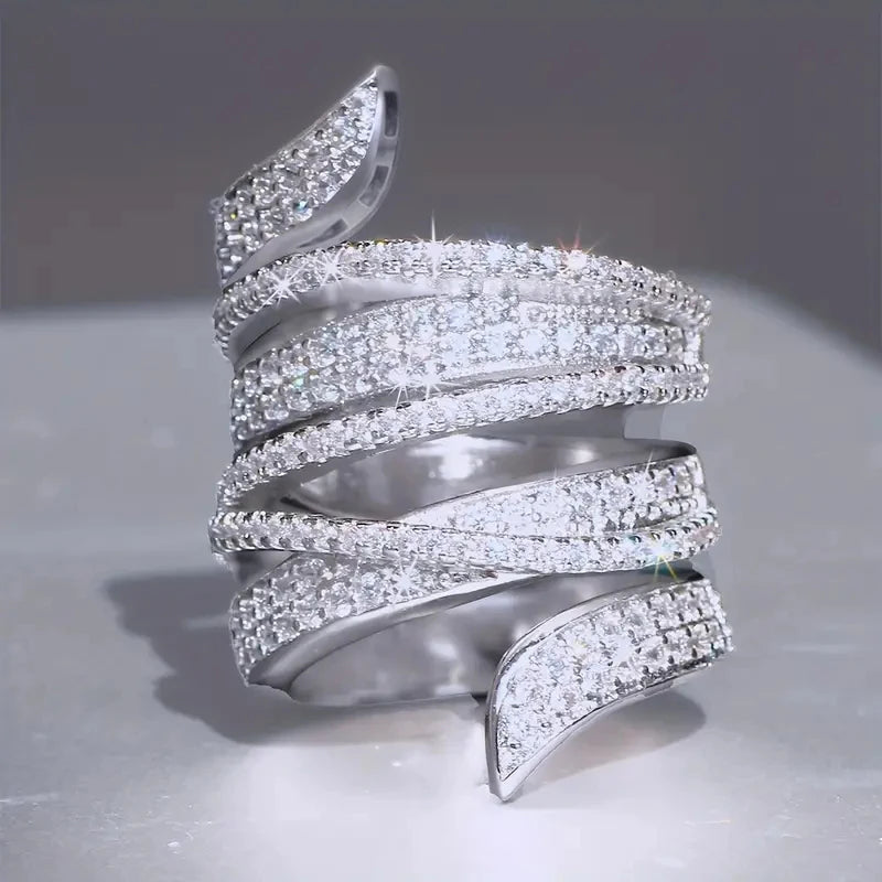 Sparkling silver-tone cubic zirconia pave wide band ring with open curved row ends.
