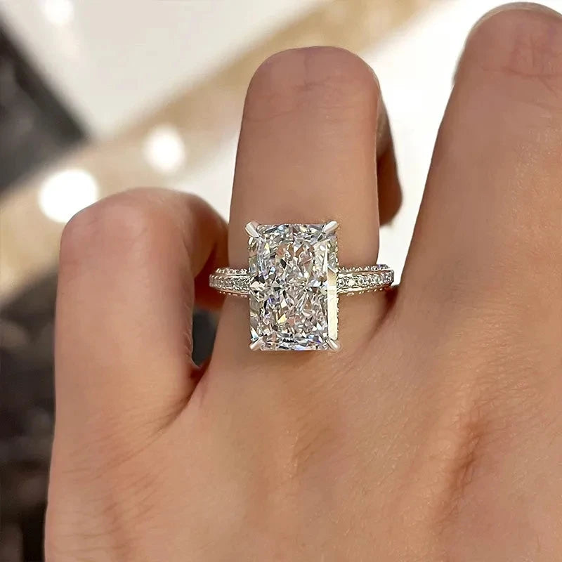 Rectangle-cut CZ ring, silver-tone band with halo bezel, shown on hand