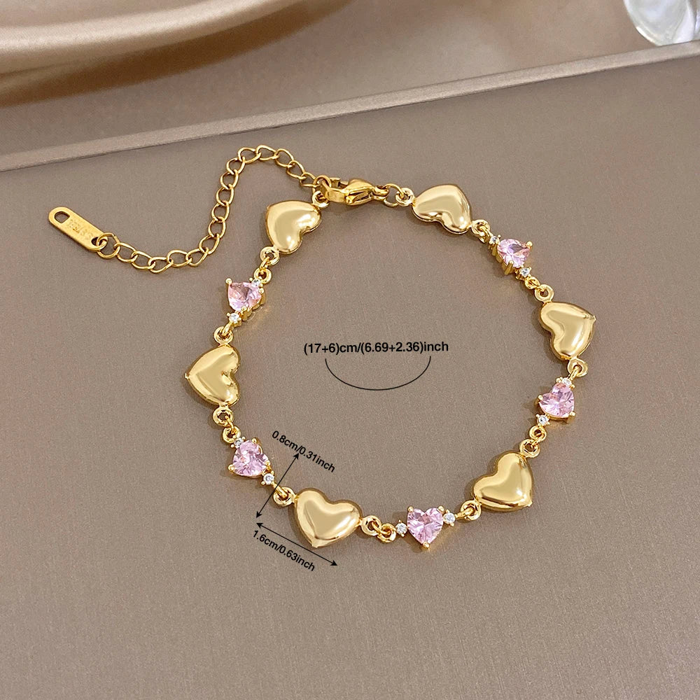 Gold-tone heart link bracelet with pink crystal-like stones and heart-shaped links