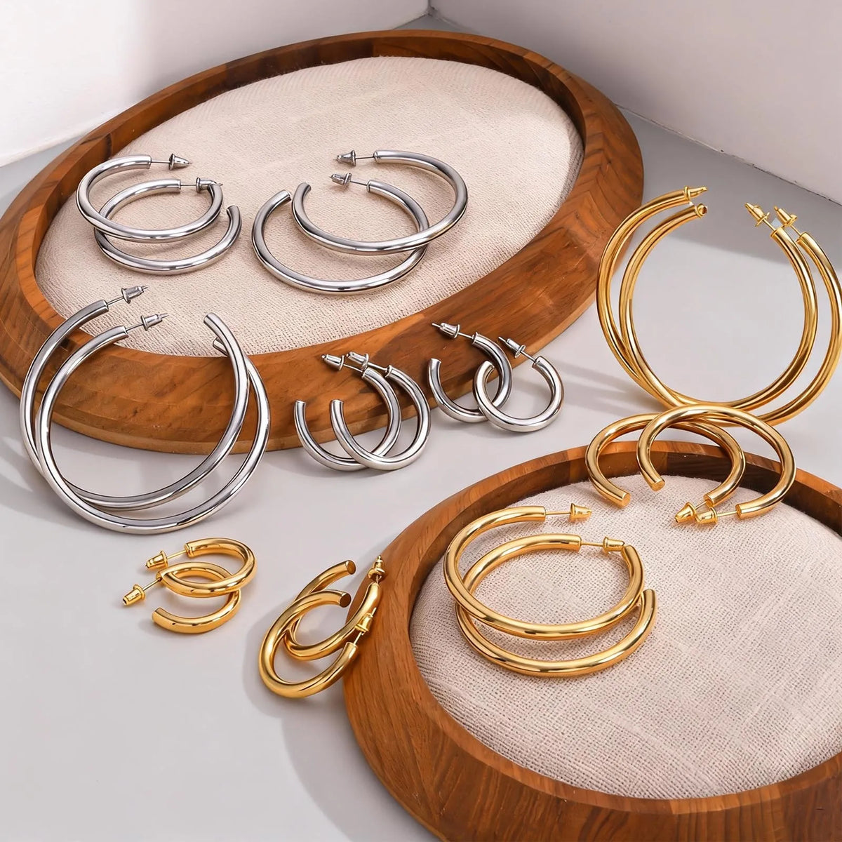 Chunky open hoop earrings in gold and silver, shown in several sizes