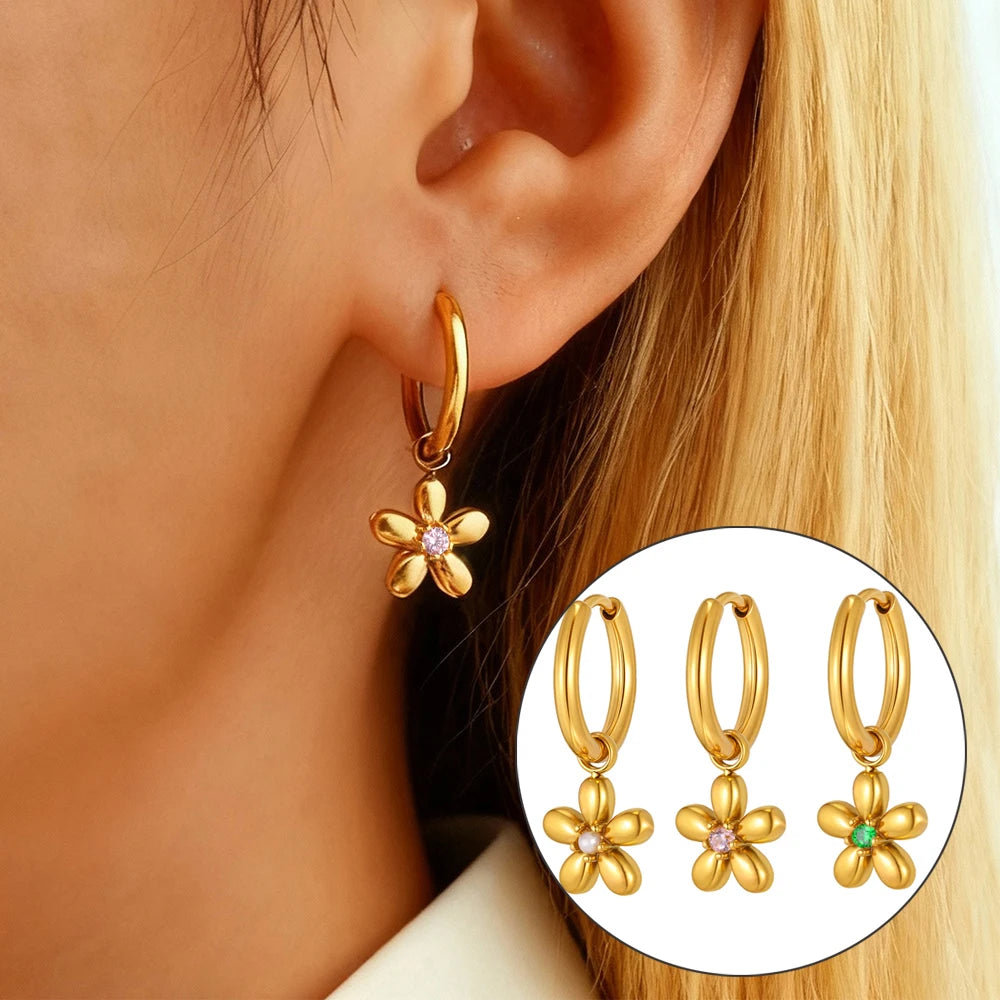 Gold flower charm hoop earring shown worn, with clear stone center; inset shows color options.