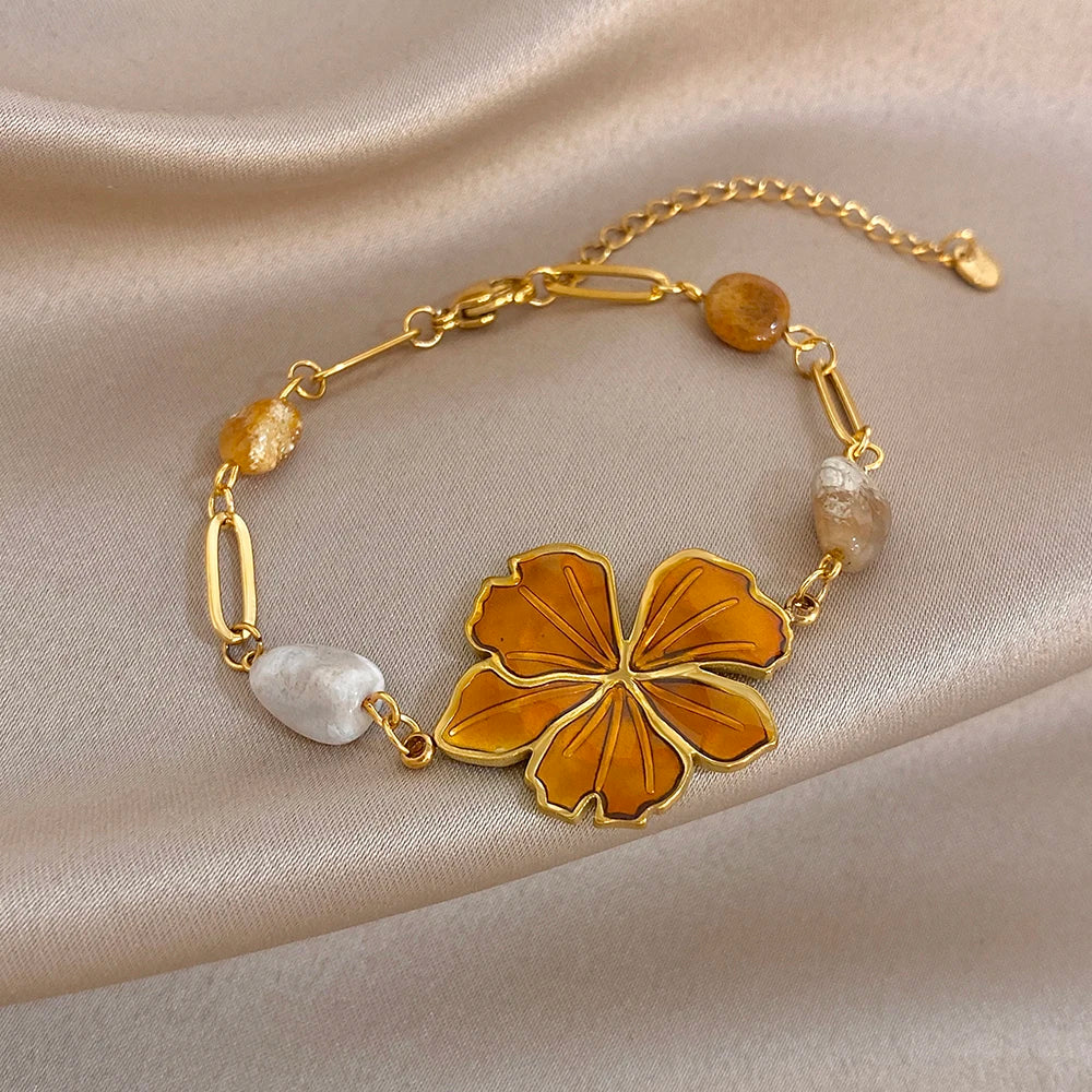 Gold plated bracelet with orange enamel flower center and mixed stone bead accents