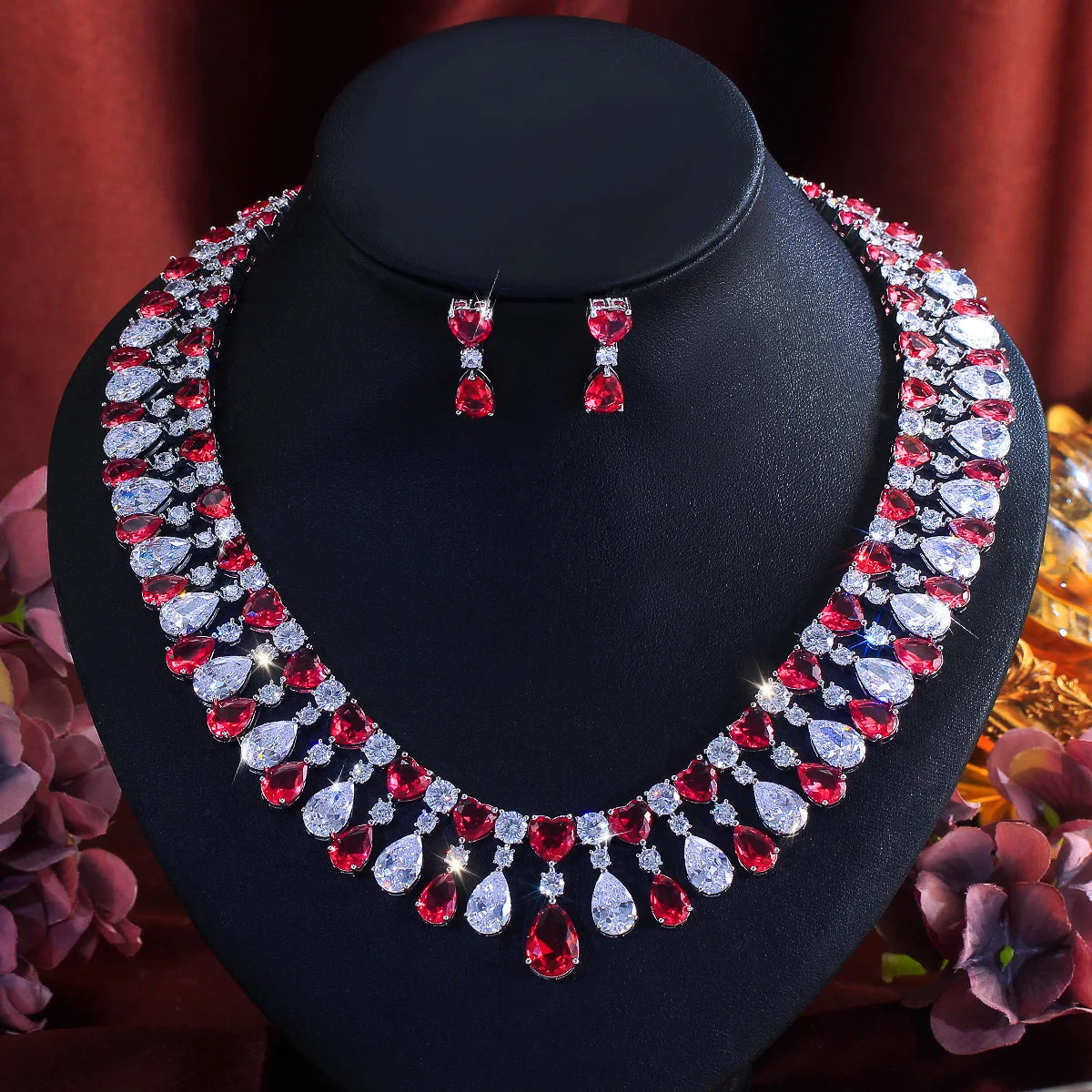 Red and clear teardrop rhinestone choker necklace with heart drop earrings on stand
