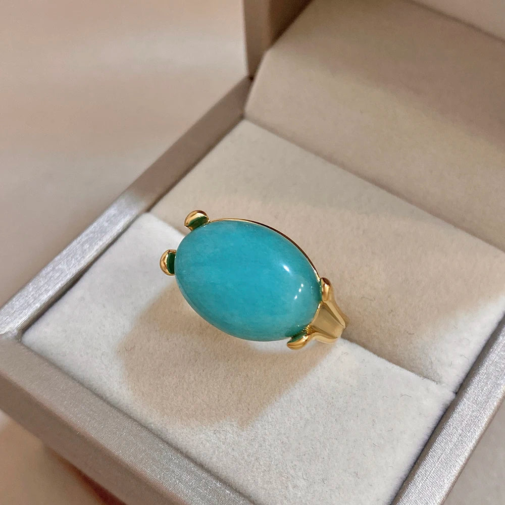 Gold-tone ring with oval turquoise cabochon stone, small side prongs