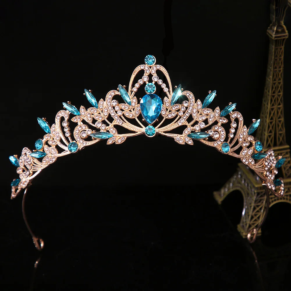 Jeweled bridal tiara crown with blue center stone and teal accents, silver floral filigree