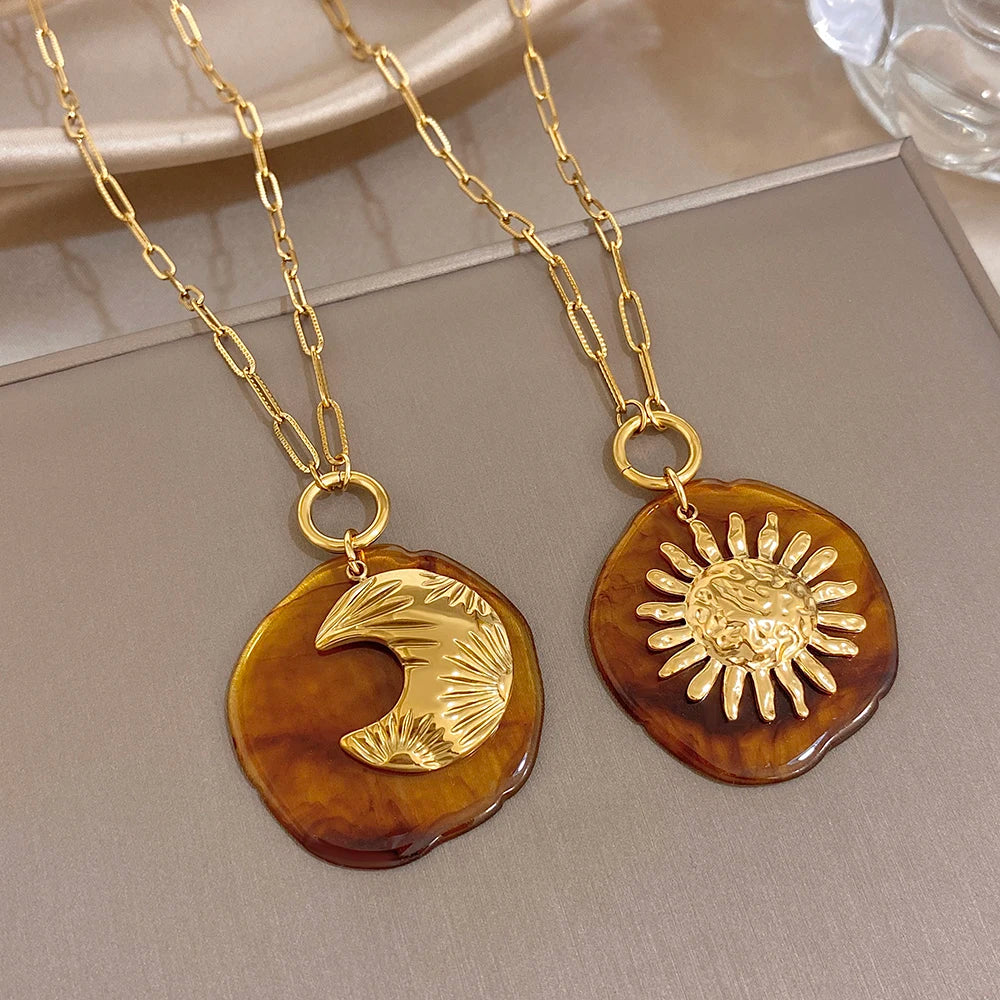 Gold-tone chain pendant necklace with amber round moon charm and textured gold figure