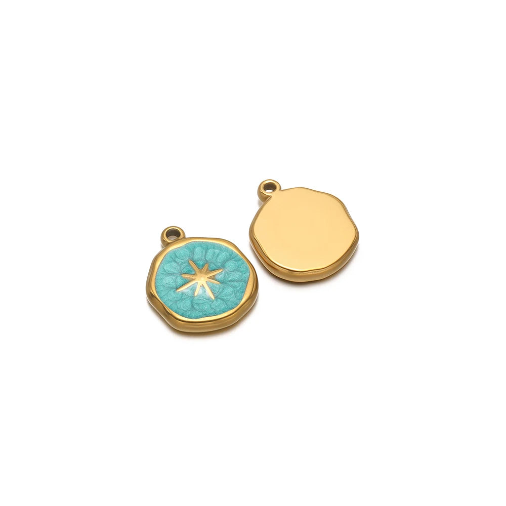 Two enamel charm pendants: gold blank disc and teal starburst icon with gold loop