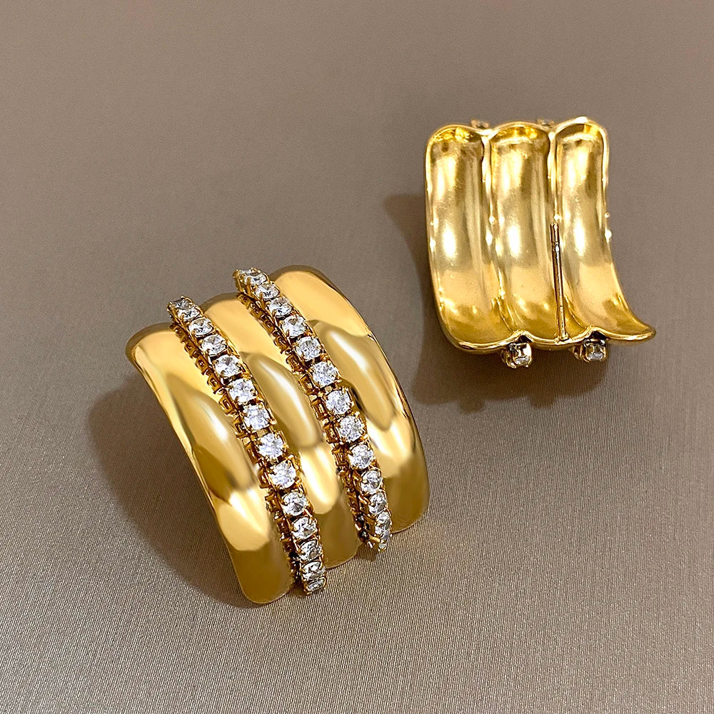 Gold-tone ridged stud earring with twin rhinestone rows; back of matching earring visible