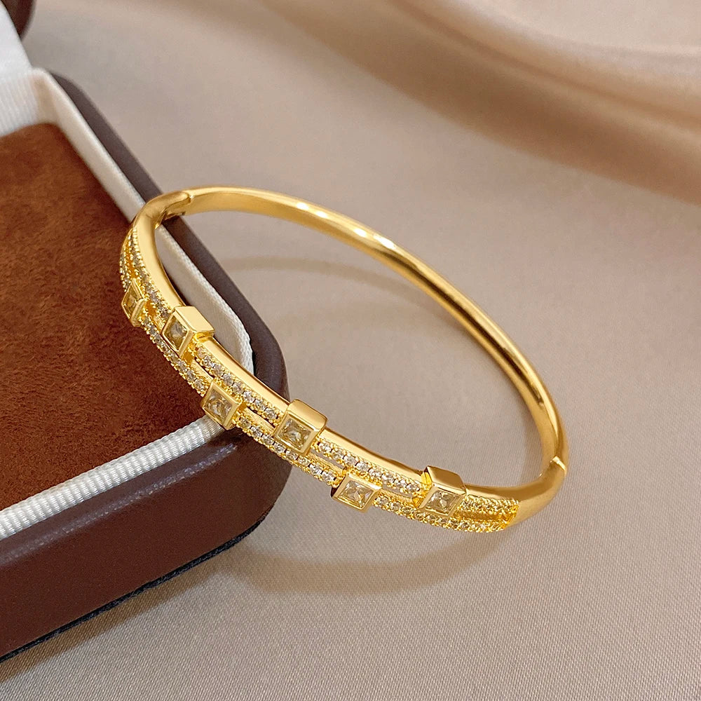 Gold-tone rhinestone bangle bracelet with square accents, worn-style close view