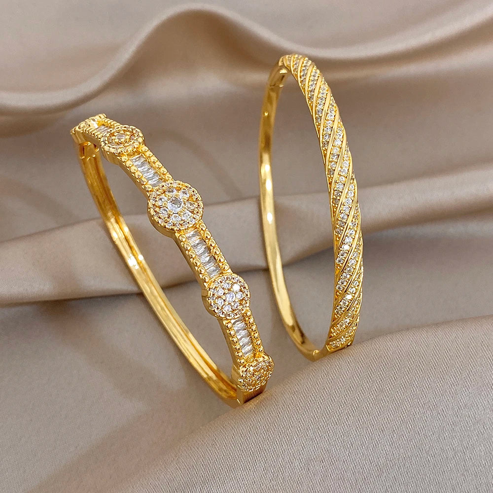 Gold-tone twisted crystal inlay bangles stacked, with flower-like motifs