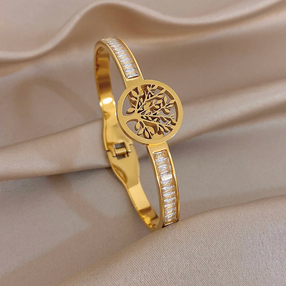 Gold-tone cuff bracelet with tree-of-life medallion and slim clear stone strip