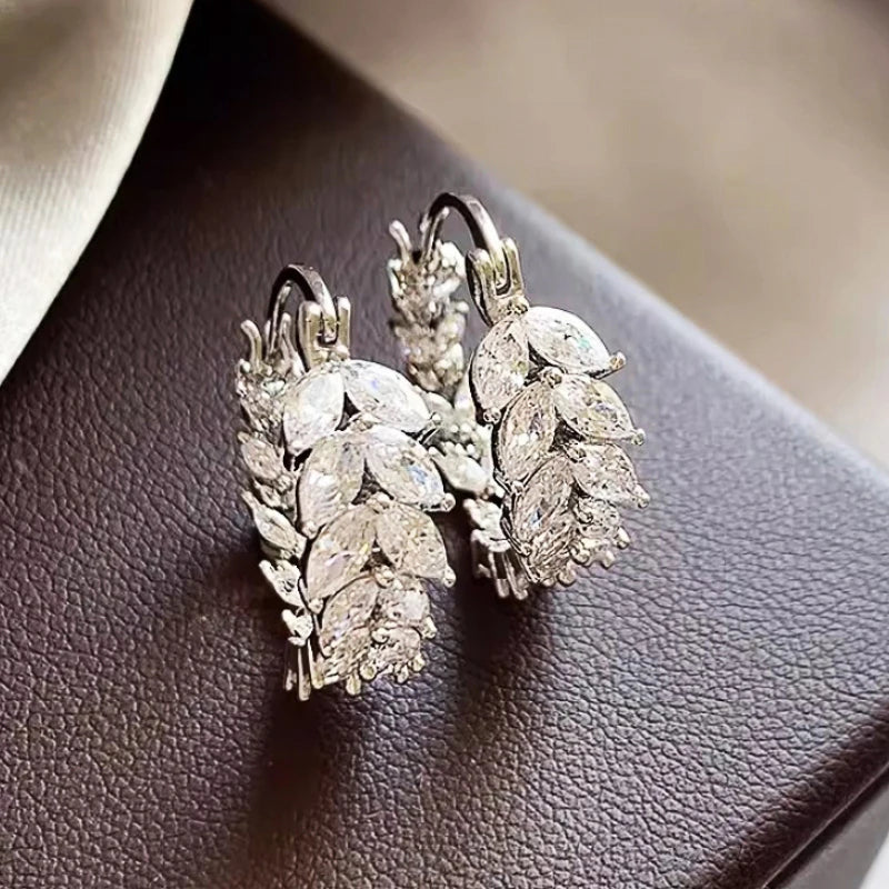 Silver cubic zirconia marquise hoop earrings with clustered stones, side-by-side close-up