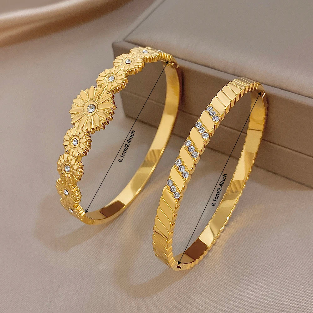 Gold tone bangles with ridged texture and clear rhinestone stripe accents