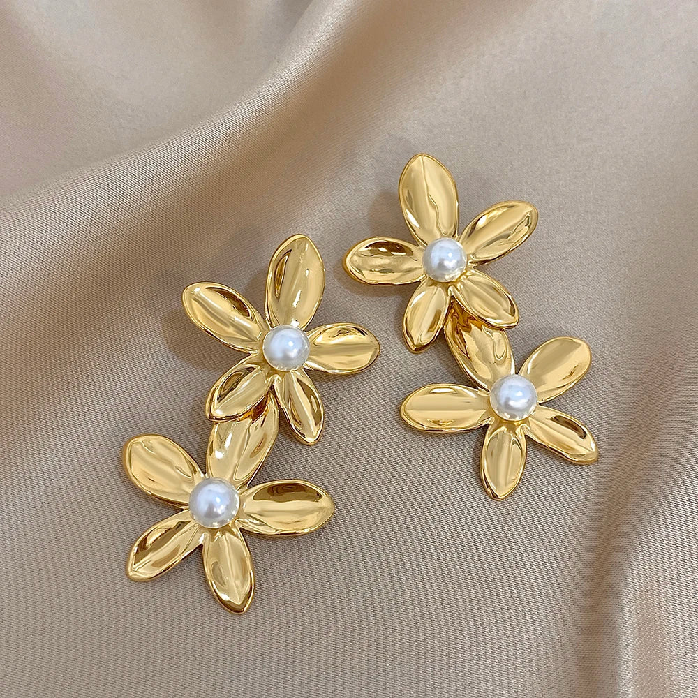 Gold-tone flower earrings with glossy petals and pearl-like centers
