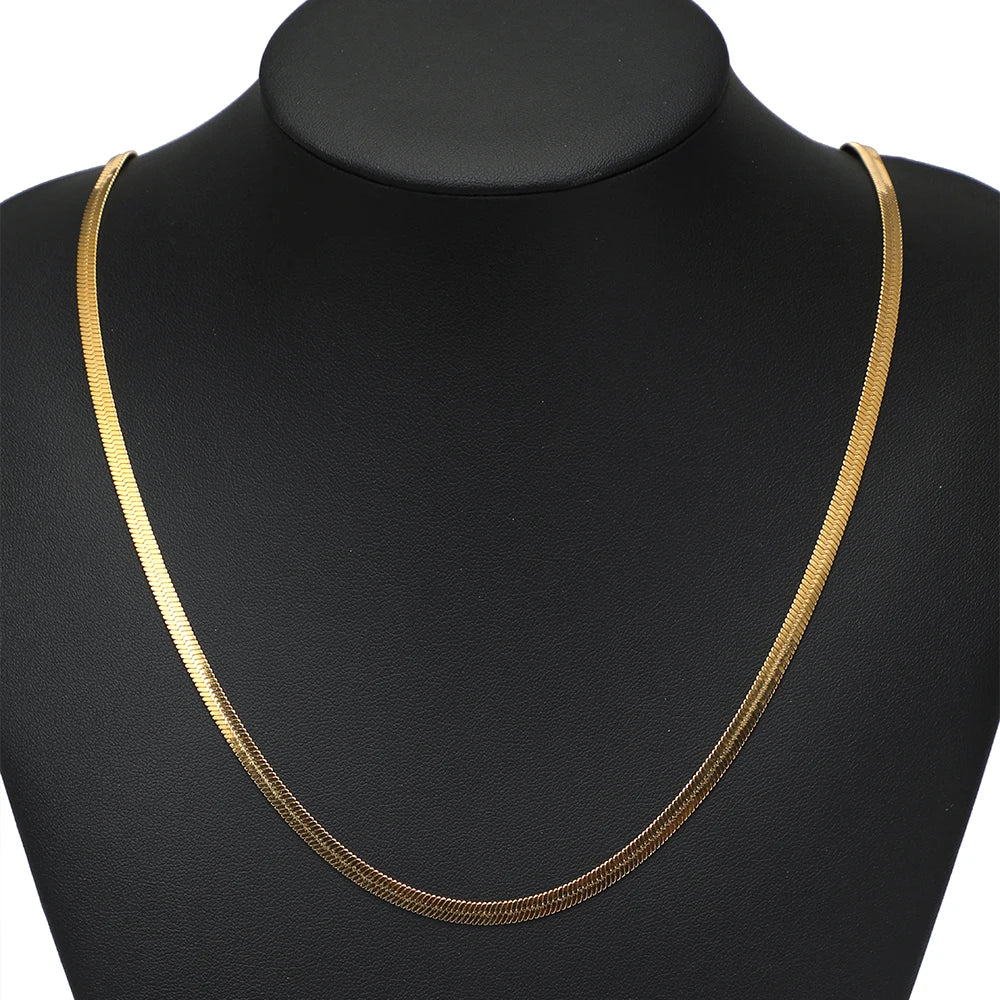 Gold flat snake chain necklace on black display, thin linked style