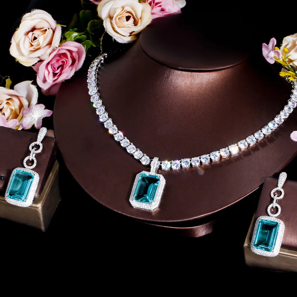 Silver-tone tennis necklace with rectangular teal cubic zirconia drops, matching earrings
