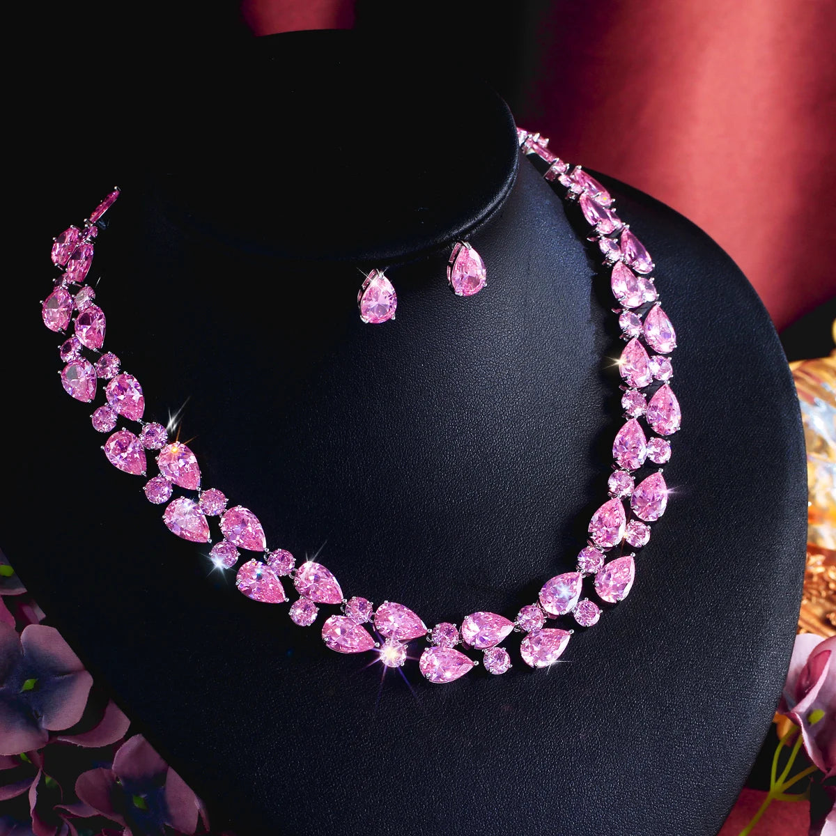 Pink teardrop rhinestone necklace with stud drop earrings on black jewelry bust
