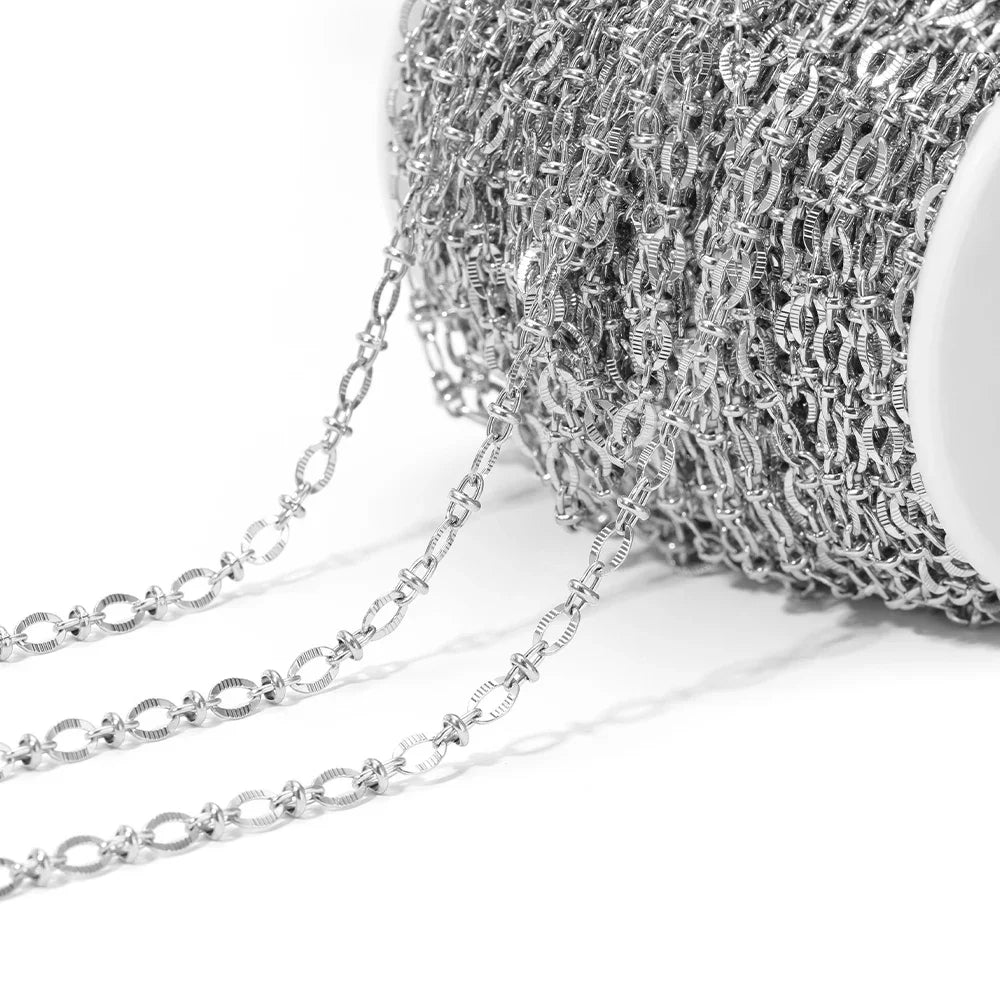 Silver embossed oval link chain bulk on a white spool with dangling links