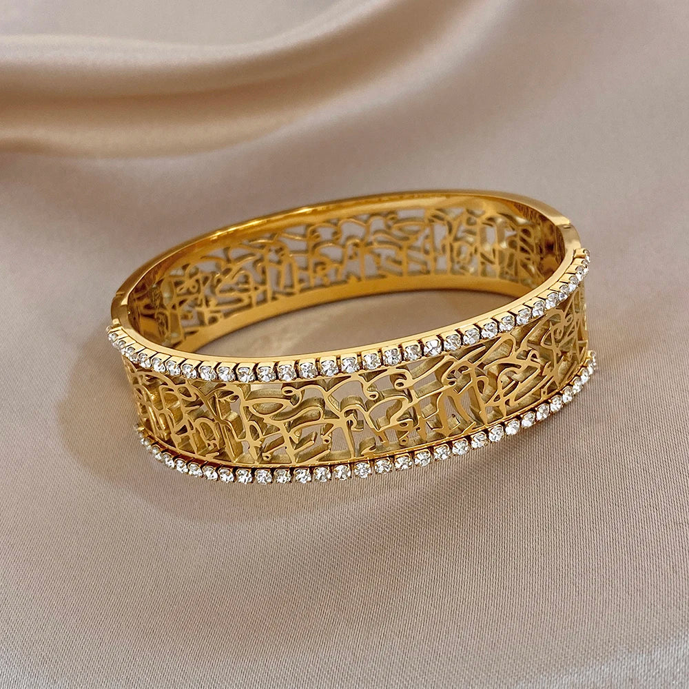 Gold-tone double-row cuff bracelet with hollow pattern and sparkling rhinestone trim
