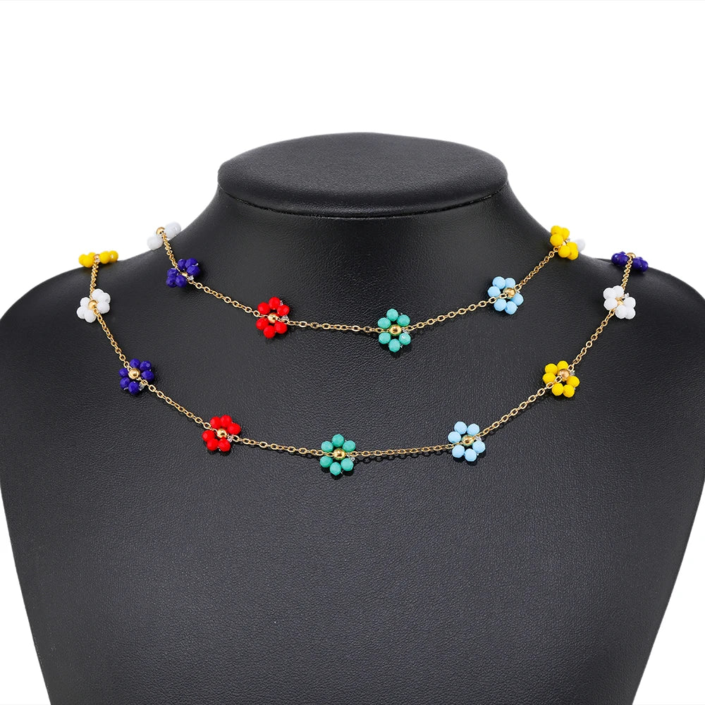 Daisy flower beaded chains in mixed colors on gold-tone links, shown on mannequin