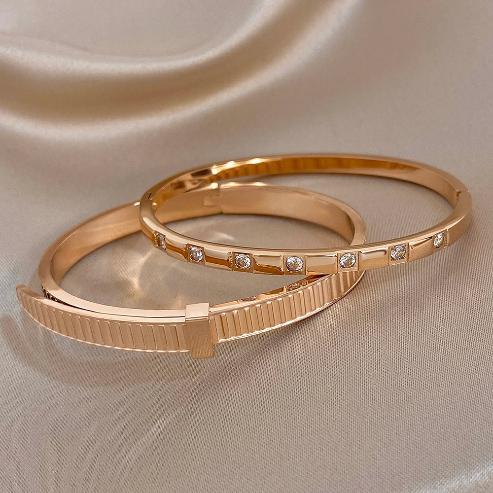 Rose gold cuff bangles, one ribbed geometric section and one with inline clear stones