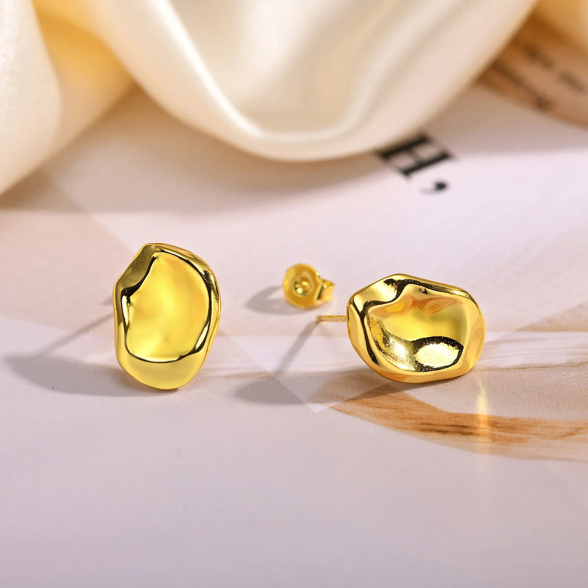 Geometric gold-tone stud earrings showing front and back with butterfly clasp