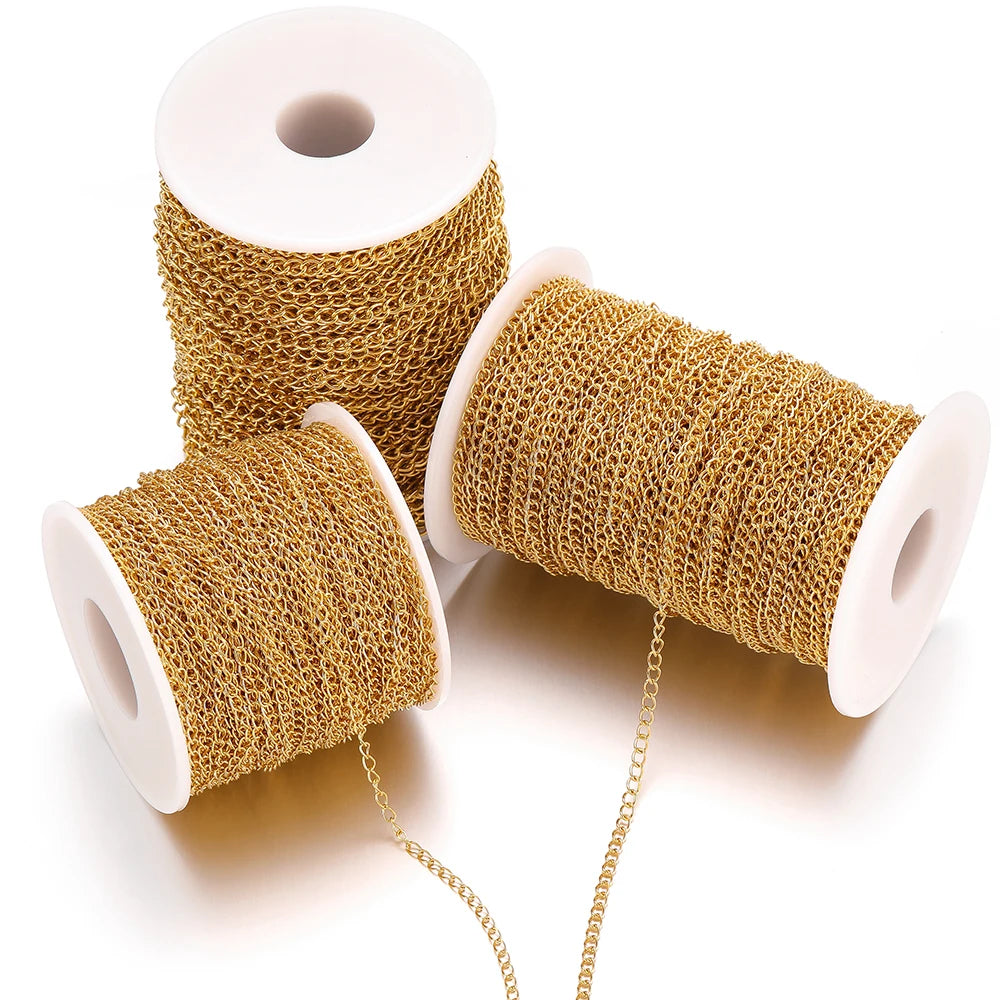 Gold chain extension links on three white spools, coiled mesh-style chain
