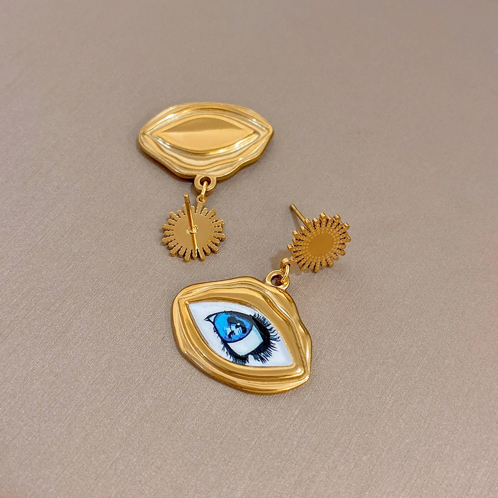 Gold-tone evil eye earrings featuring an oval eye charm, with sunburst drop details