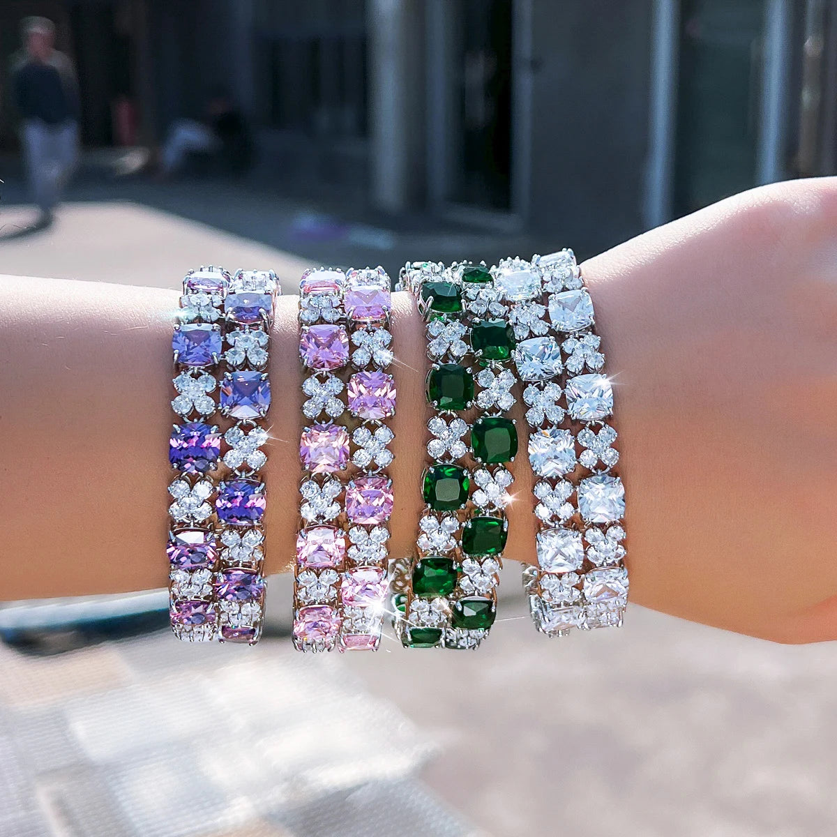 Four cubic zirconia tennis bracelets with flower-shaped clear stones and purple, pink, green, or clear gems