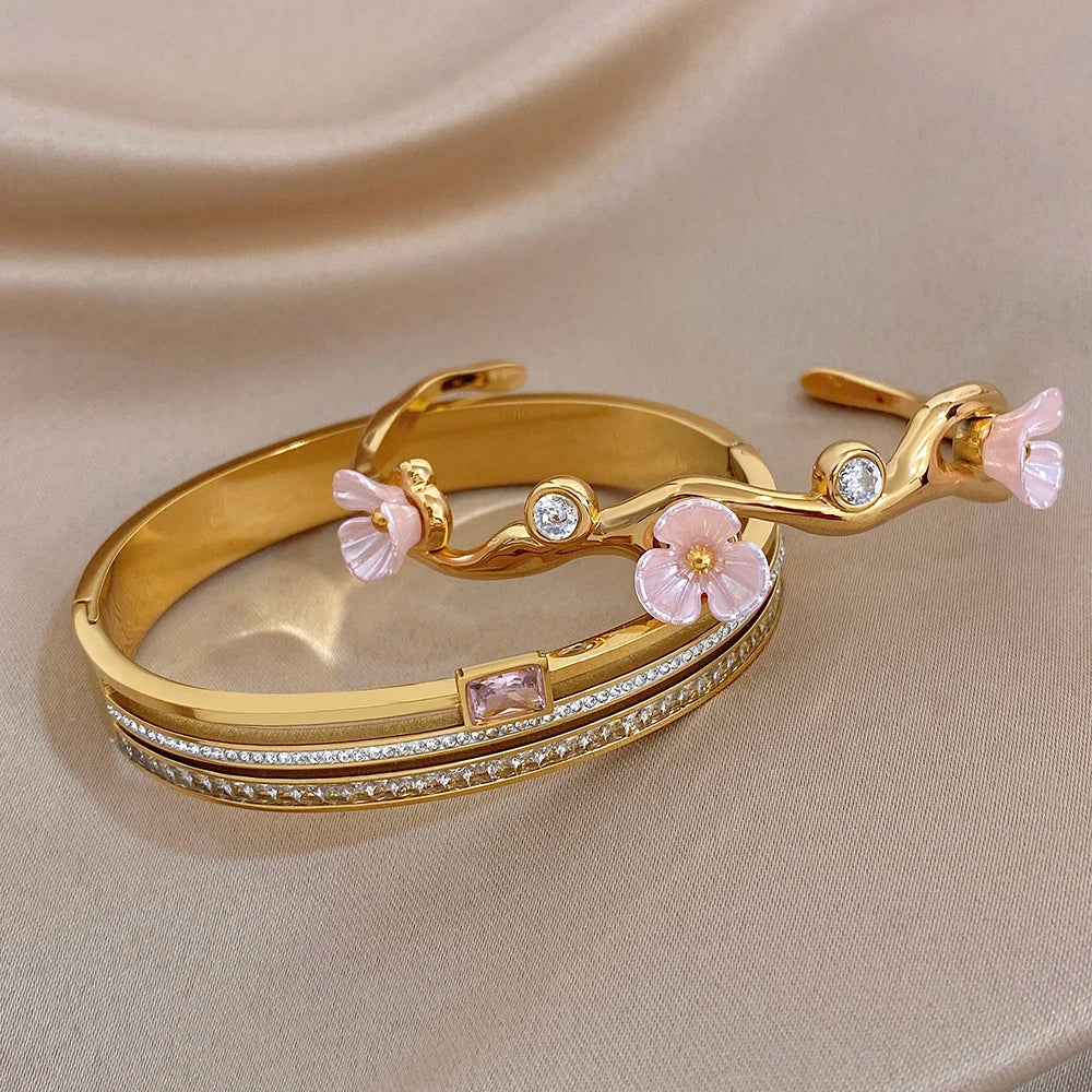 Gold-plated cuff bangle with pink flower charms and small round rhinestones