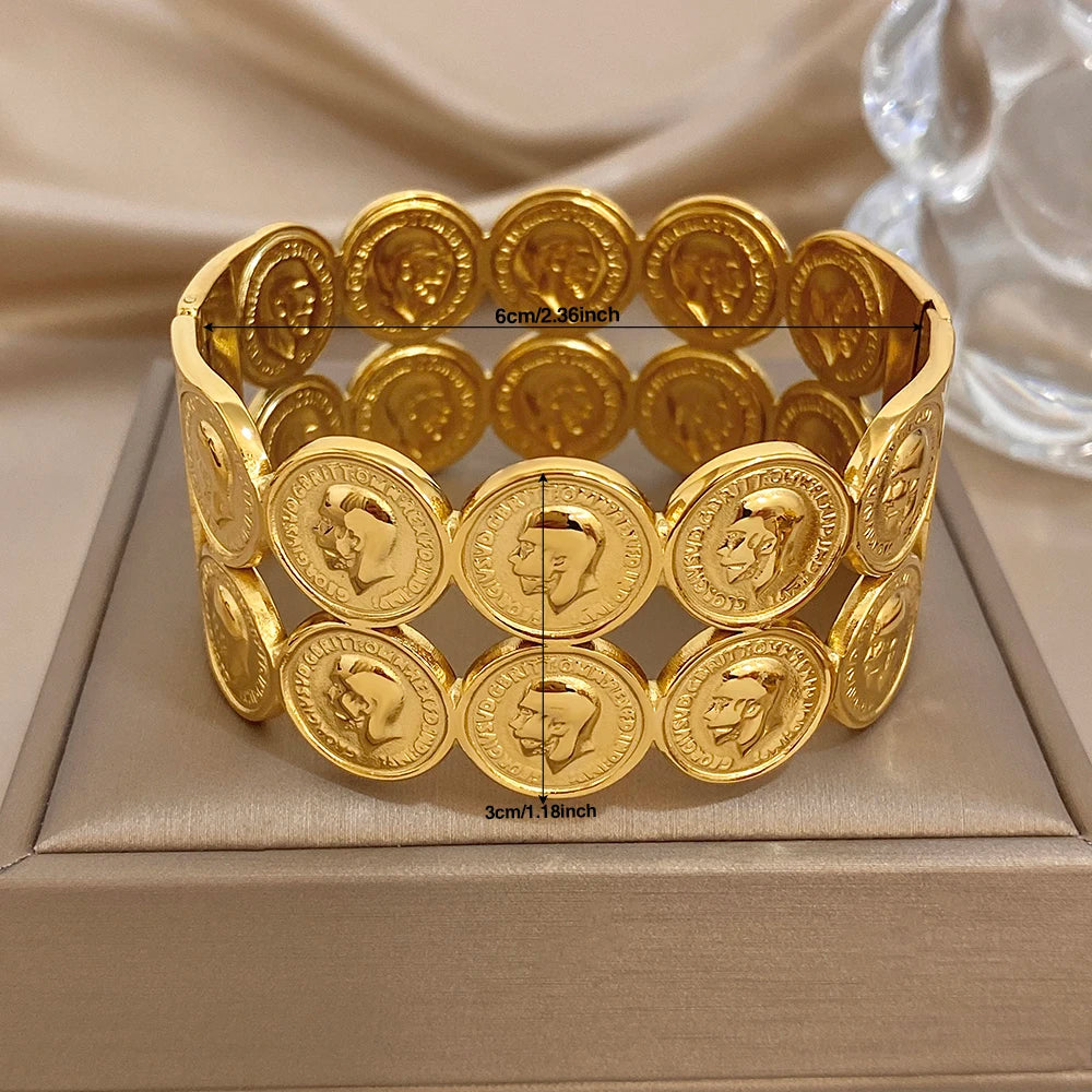 Gold plated cuff bangle with round coin medallion discs and human face motifs